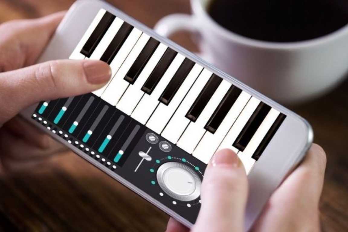 Persona utilizando un teclado virtual en el móvil para practicar música digitalmente